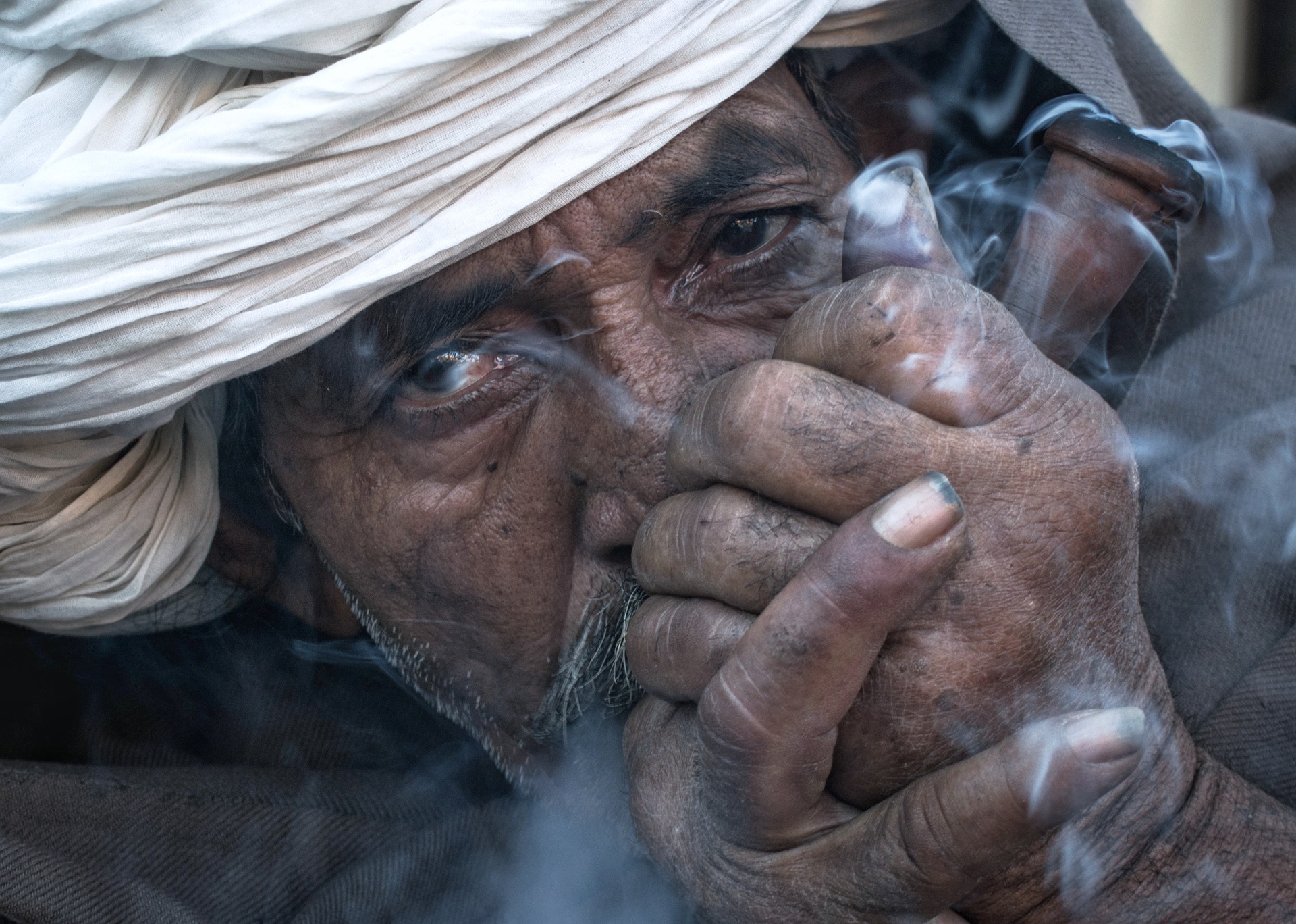 Elmélyülten dohányzó markáns arab férfiarc.
